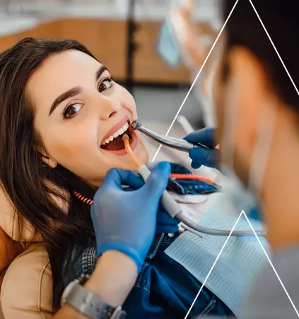 Foto de um dentista realizando um atendimento em uma paciente